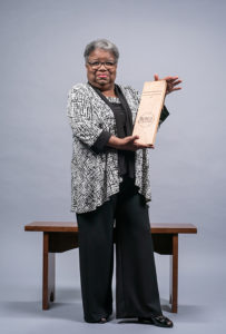 Sharyn Mitchell holding an alumni award