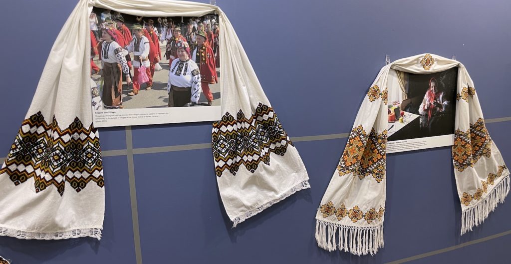 Pair of photos on the wall draped with Ukrainian textile decorations