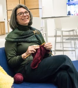 Dr. Megan Hoffman, smiling and knitting