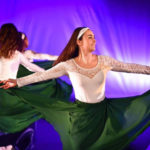 BMED performers wearing green skirts and white blouses with lace