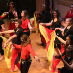 BMED Dancers performing with vibrant yellow and red outfits