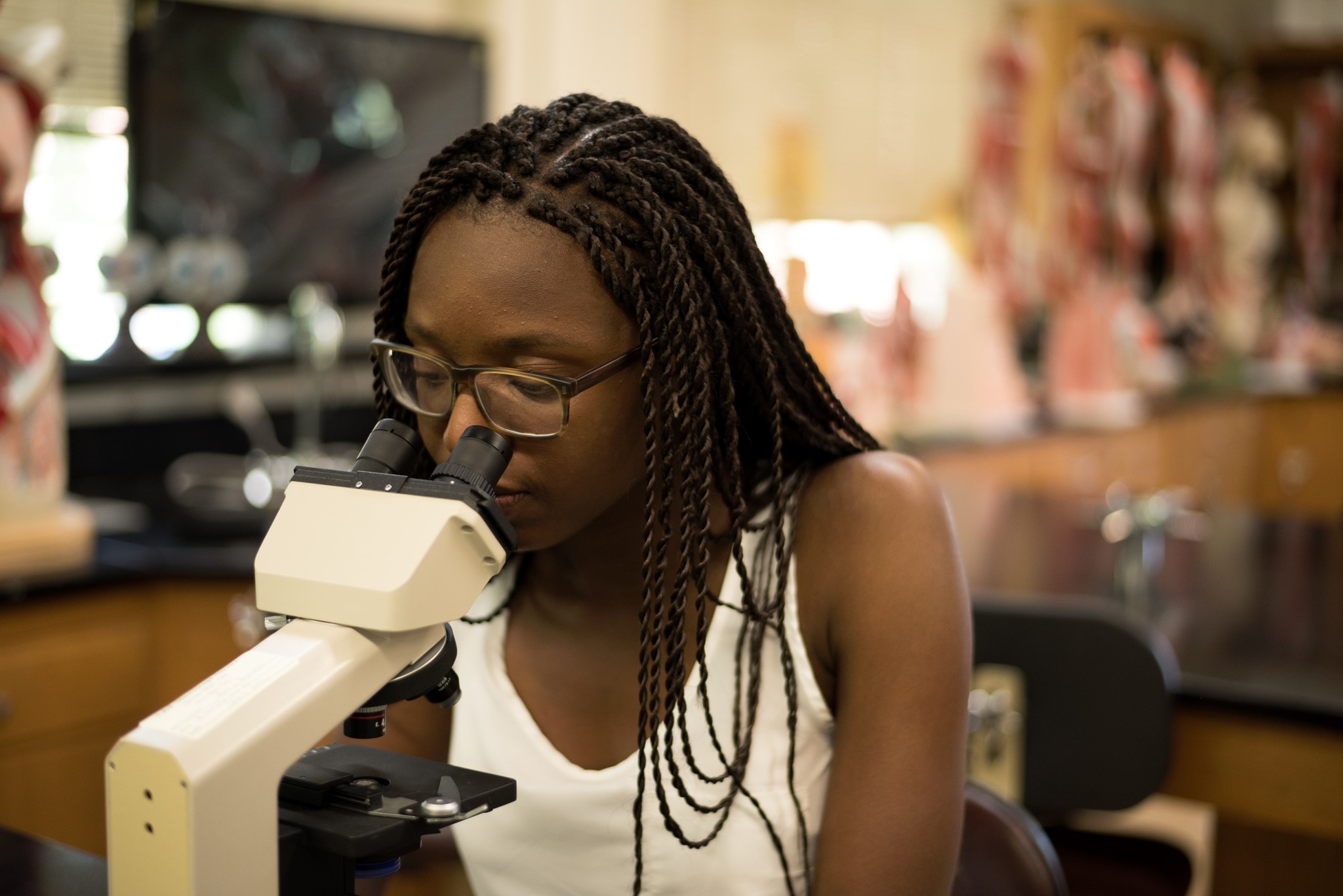 A student looking through microscope