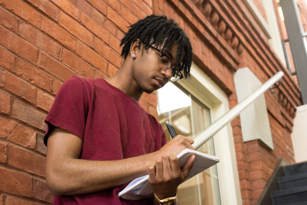 Student holding a notebook and pen