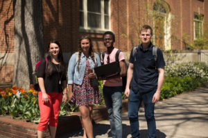 4 students posing on campus outside
