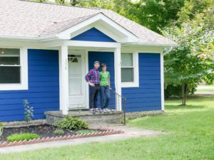 A picture of Rebecca, her partner, and the new house.