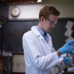 A student, Seth Reasoner working in the science lab