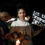 students holding sign "let the dreamers dream" to support DACA