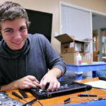Student fixing laptop
