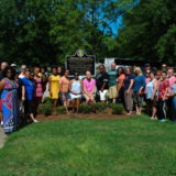 Civil Rights Tour group gather for a photo in front of historical sign "Memorable Quotes from Letter from Birmingham Jail"