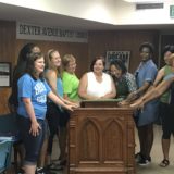 Faculty and staff placed their hands on the pulpit Dr. King used when he was the pastor of Dexter Avenue Baptist Church