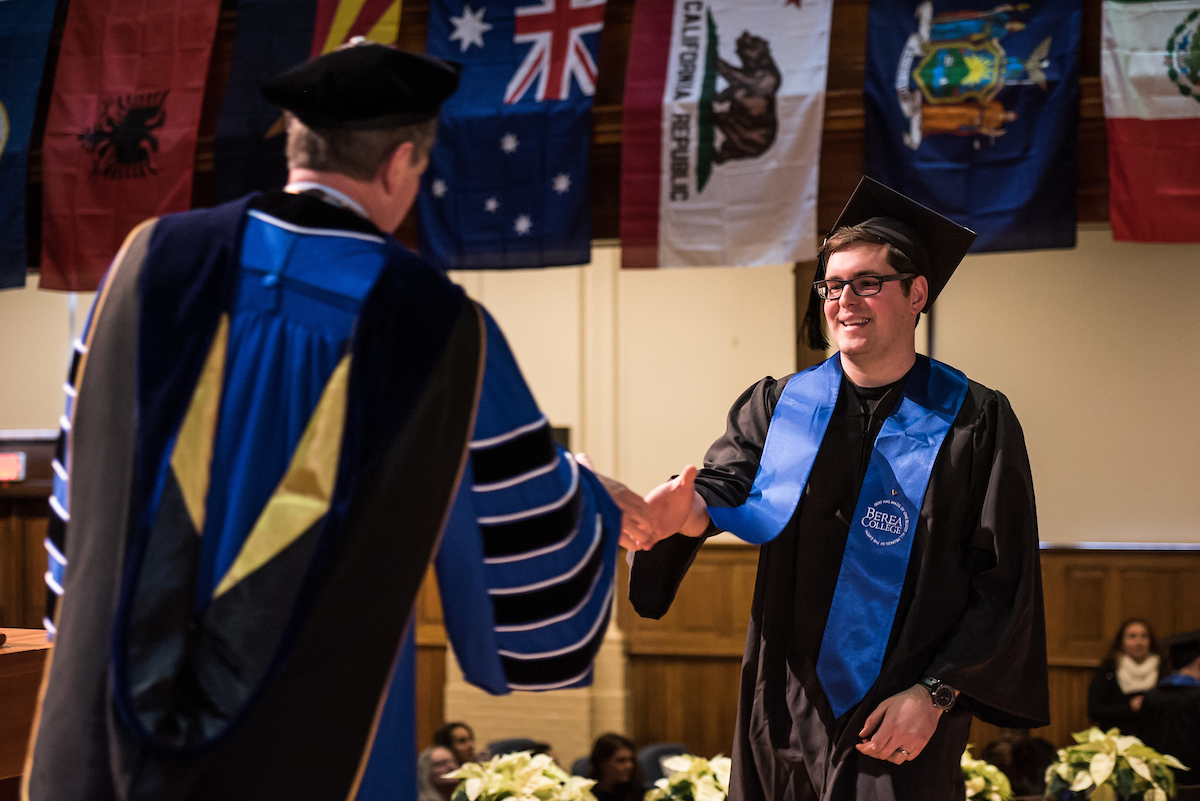 Student shaking Pres. Roelofs' hand as he accepts his diploma