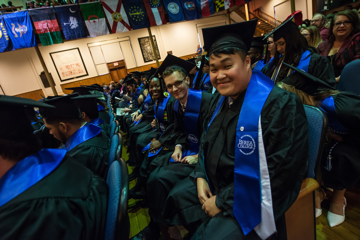 Smiling graduates in the floor seats