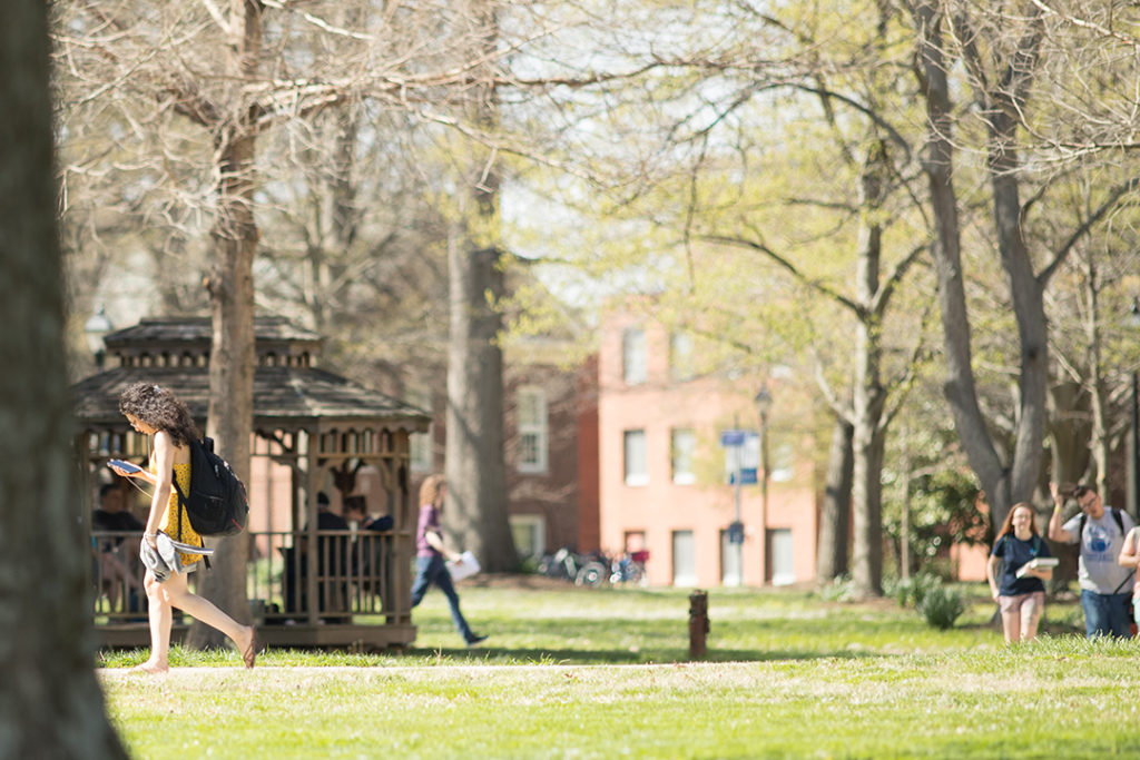 Students walking across campus with a gazebo in the background