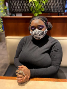2021 Civic Newman Fellow Autumn Harvey sitting at a table, wearing a mask